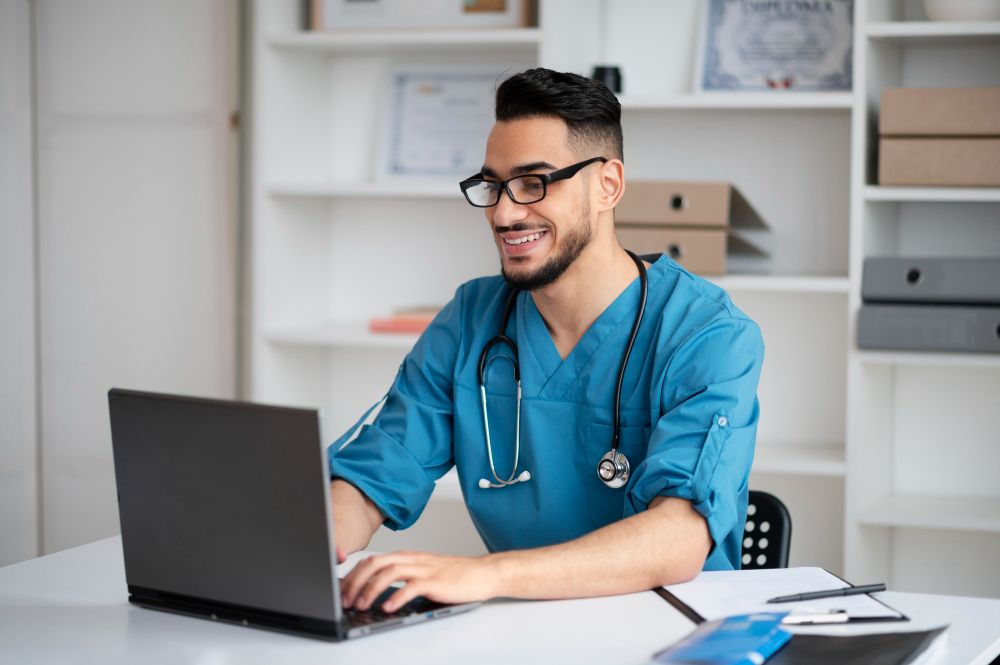 Young doctor using a laptop while exploring Care Bridge opportunities